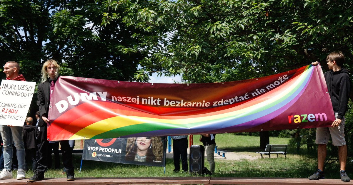 Aktywistki i aktywiści Partii Razem trzymają tęczowy baner z napisem „DUMY naszej nikt bezkarnie zdeptać nie może” podczas Pikniku Równości w Kaliszu